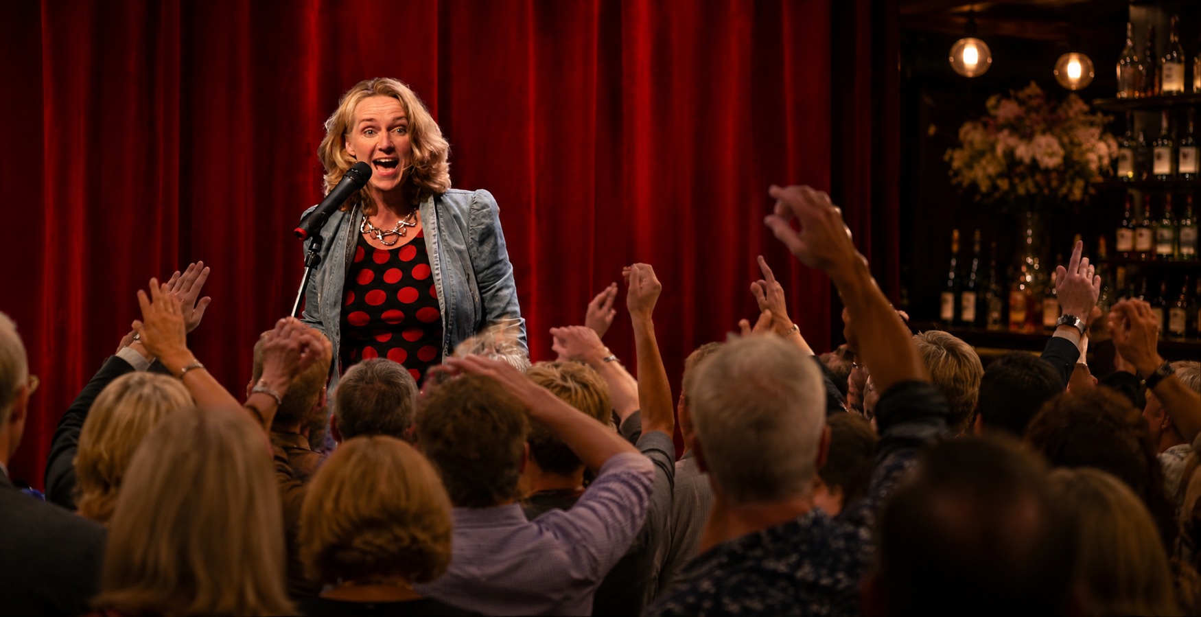 Anke Siegers op het podium, publiek steekt de handen op